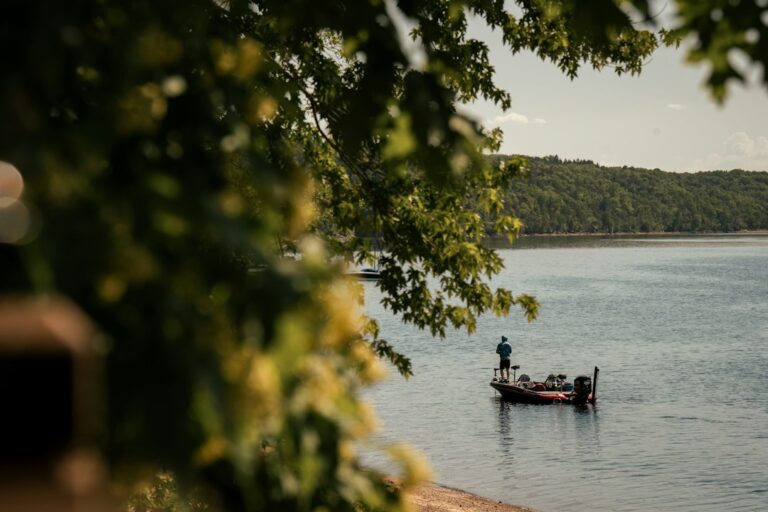 An angler fishing from a boat on a freshwater river.